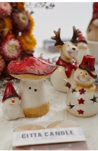 Detail of ceramic Christmas mushroom house with snowman and deer festive ornaments