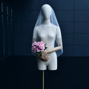 Elegant white medium bridal veil with beaded tassel edges and comb on mannequin
