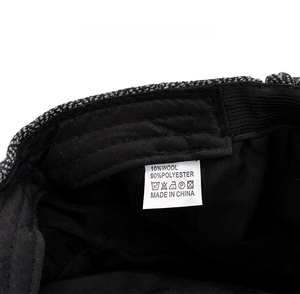 Detail of tweed newsboy cap inner lining showing the wool blend material care label