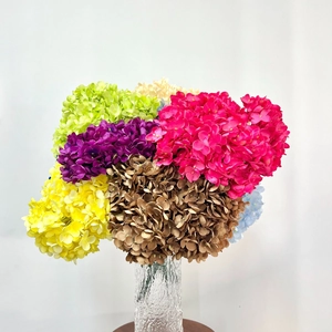 Close-up of vibrant artificial hydrangea bouquet in a textured glass vase