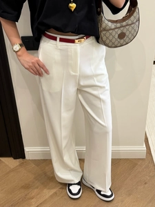 Close-up of high-waist white straight-leg trousers with elegant draping and suit fabric