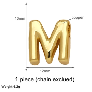 Macro detail of 13mm gold plated copper M letter pendant with specific size and weight info
