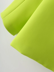 Gros plan sur la texture du tissu vert citron et les détails de la manche du blazer