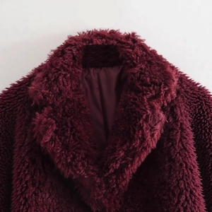 Cappotto in finta pelliccia rosso bordeaux con collo spesso su sfondo bianco