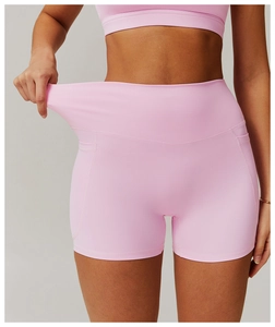 Close-up of pink high waist yoga shorts showing elastic waistband and side pocket detail