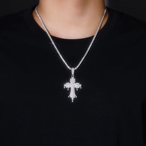 Macro shot of silver hip-hop cross pendant with sparkling stones on a tennis chain