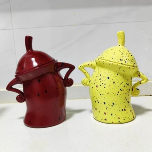 Close-up of colorful ceramic storage canisters with lids and unique spotted patterns