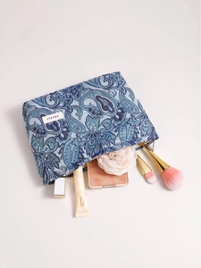 Blue paisley makeup bag with H&R label shown with various cosmetic products