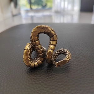 Macro shot of retro brass dragon sculpture featuring realistic scale textures and finish