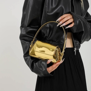 Glossy gold metallic mini handbag underarm bag shown by model on white background