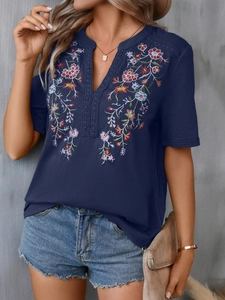 Detailed view of the V-neck and intricate floral embroidery on a navy short-sleeve top