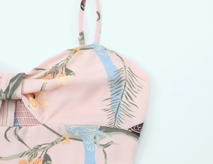 Détail de robe rose à fleurs avec imprimés d'oiseaux, tissu froncé et fermeture invisible
