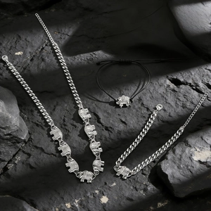 Detail of vintage silver elephant pendant on chain necklace and woven bracelet set