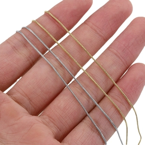 Polished gold and silver stainless steel snake chains held by hand to show fine thickness