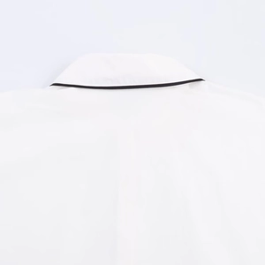 Close-up of white poplin shirt collar with high-contrast black contrast piping detail