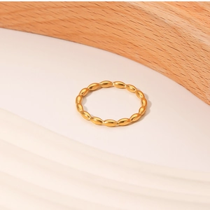 Macro detail of minimalist gold stackable ring with olive shaped geometric patterns