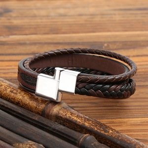 Men's multi-layer braided leather bracelet with silver magnetic clasp on wooden background