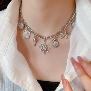Detailed view of silver necklace featuring conch, starfish, and turtle charms on a model