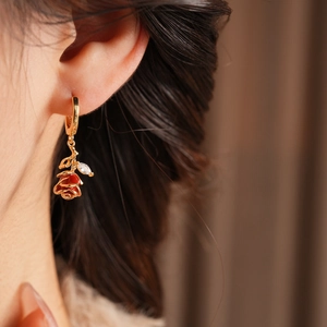Gros plan de boucles d'oreilles vintage fleurs en émail rouge et zircon sur un mannequin