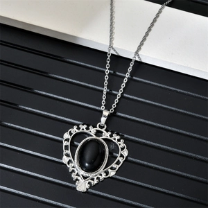 Détail du pendentif en cœur évidé avec onyx noir sur une fine chaîne en métal argenté
