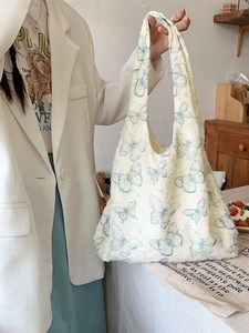 Chic beige canvas tote bag featuring blue butterfly prints and textured frayed edges