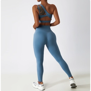 Detail view of one-shoulder yoga sports bra with irregular straps and high waist leggings