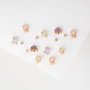 Close-up of gold-plated space earrings set with colorful gemstones and crystals