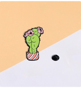 Close-up of funny cactus enamel pin with butt-shaped design and pink flower detail