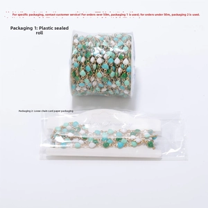 Detail of colorful heart beaded chain in green and blue with gold links in packaging