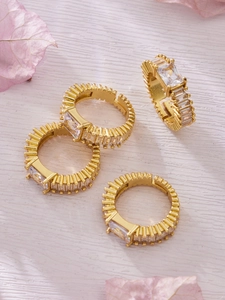 Macro detail of gold plated geometric rings with zircon crystals and vintage serrated edges