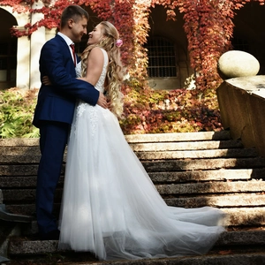 Detail view of the elegant white lace wedding dress with a long tulle train and embroidery