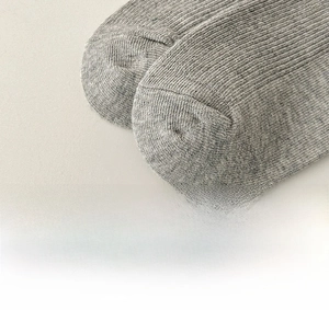 Detailed macro view of reinforced toe stitching on grey knit crew socks for women
