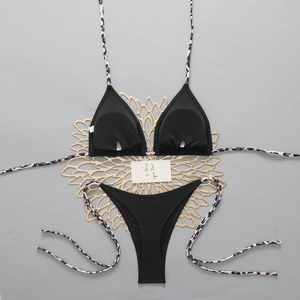 Flat lay of black triangle bikini set with leopard print straps and side ties