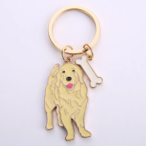 Détail d'un porte-clés doré avec un pendentif Golden Retriever et un petit os blanc