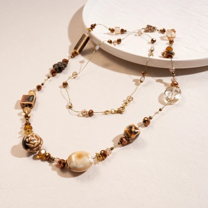 Detail of vintage beaded necklace featuring brown glass and ceramic butterfly beads