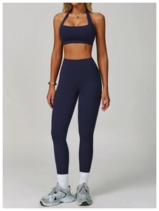 Detail of high-waist yoga leggings and halter sports bra set in navy blue fabric