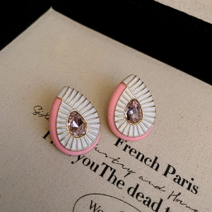 Detailed macro view of French vintage teardrop earrings with pink enamel and gold trim