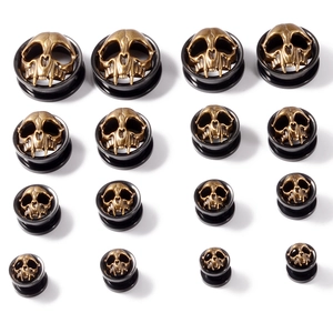 Detail showing multi-size skull ear plugs set in antique bronze and black steel