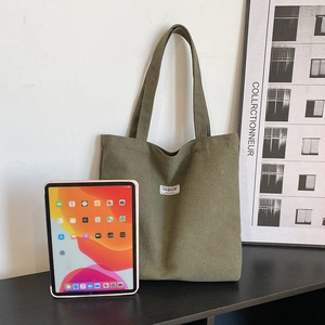 Thick army green canvas tote bag for daily use shown next to an iPad for scale