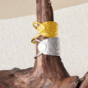 Detailed macro view of gold and silver hammered metal rings on a natural wood branch