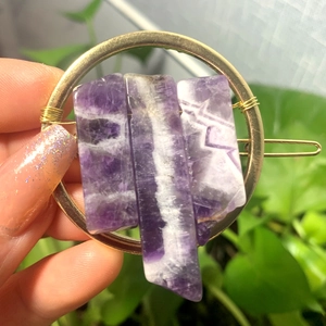 Detail of natural purple raw crystals fixed on a round golden geometric hair clip
