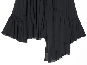 Detail showing multi-layered ruffled hem of black chiffon blouse with delicate rolled edges