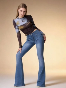 Detailed side view showing slim fit stitching and retro flare hem of light blue denim jeans