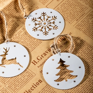 White metal Christmas ornaments set with snowflake, reindeer, and tree on vintage paper