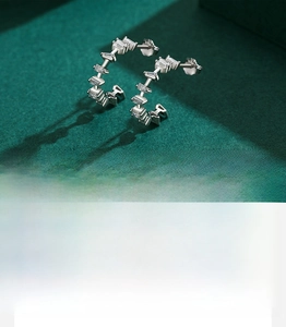 Detail of C-shaped silver earrings with hand-set 5A grade rectangular cut zircons