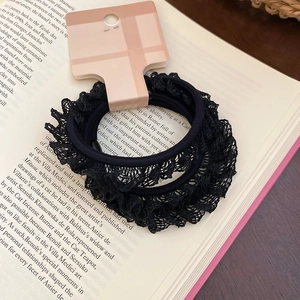 Détail de chouchous à bordure en dentelle noire sur pages de livre pour coiffure rétro