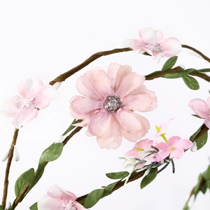 Bohemian floral headband with pink blossoms and green leaves on brown rattan vine