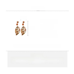 Detail view of amber texture leaf earrings showing 8.5cm x 2.8cm size and acetate material