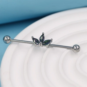Vue rapprochée du piercing industriel argenté avec trois pierres marquises irisées
