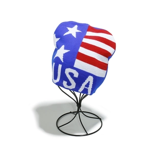Close-up of USA knit beanie featuring American flag stars and stripes on a stand